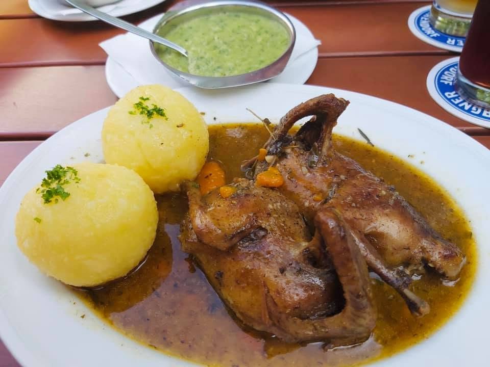 Ein Teller mit Braten, Klößen und Gemüse